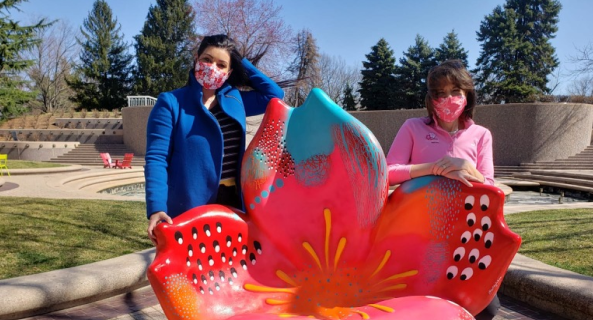 women taking a photo with the "Art in Bloom" public outdoor installation