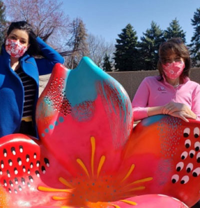 women taking a photo with the "Art in Bloom" public outdoor installation